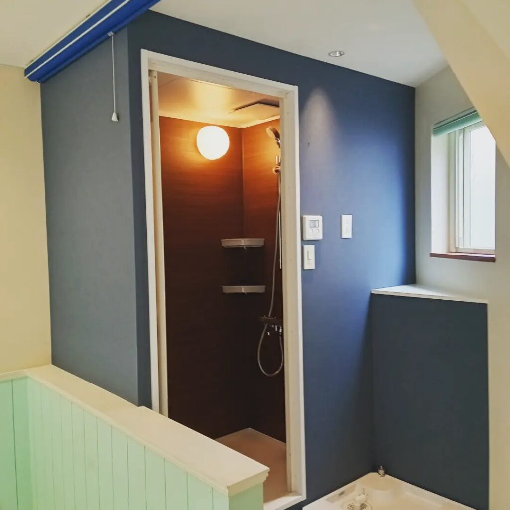 “TOTOシャワールームと紺色の壁紙が生み出す、落ち着きの空間”
