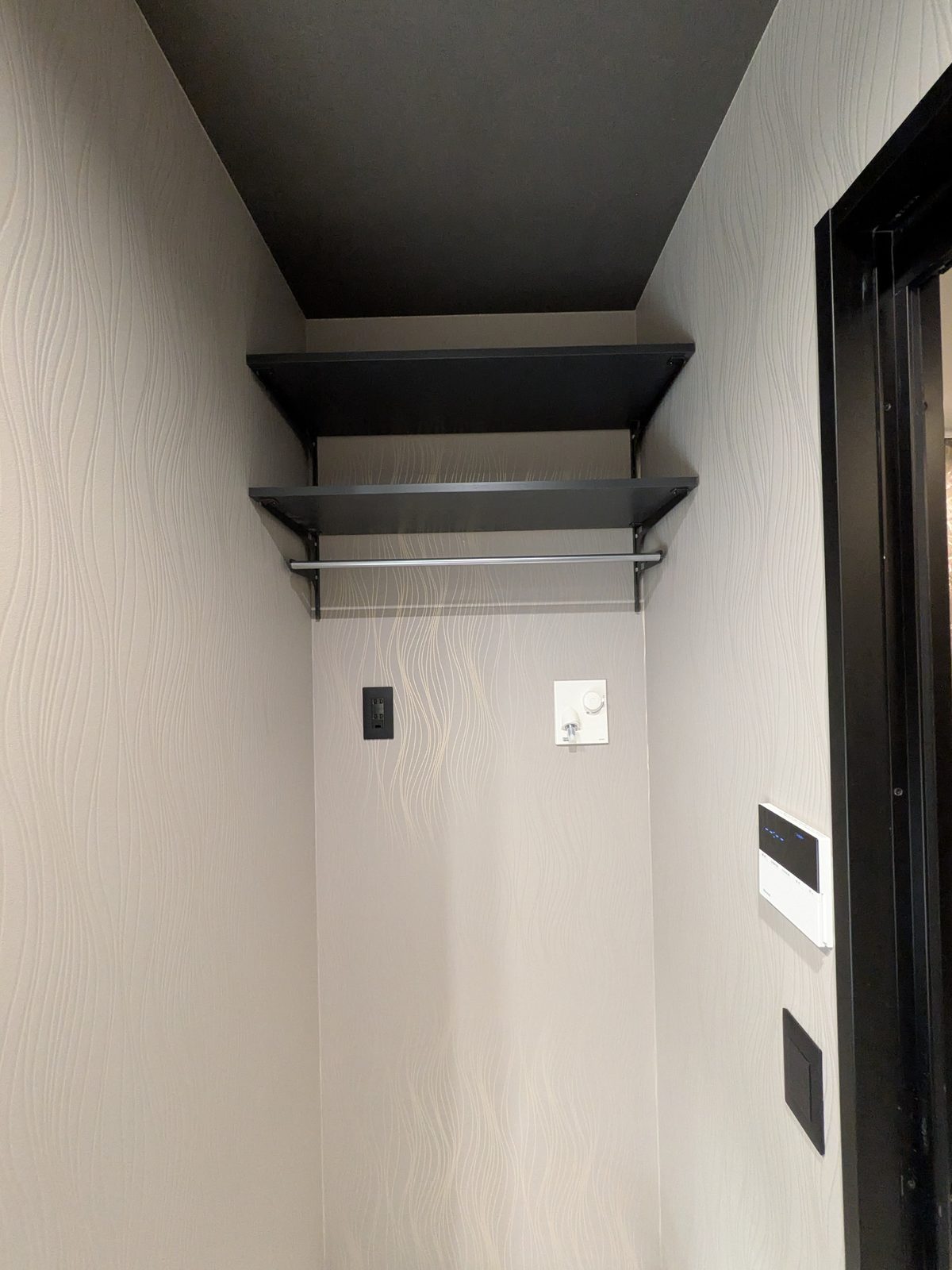 リノベーション後の洗濯機置場。黒い可動棚を造作した