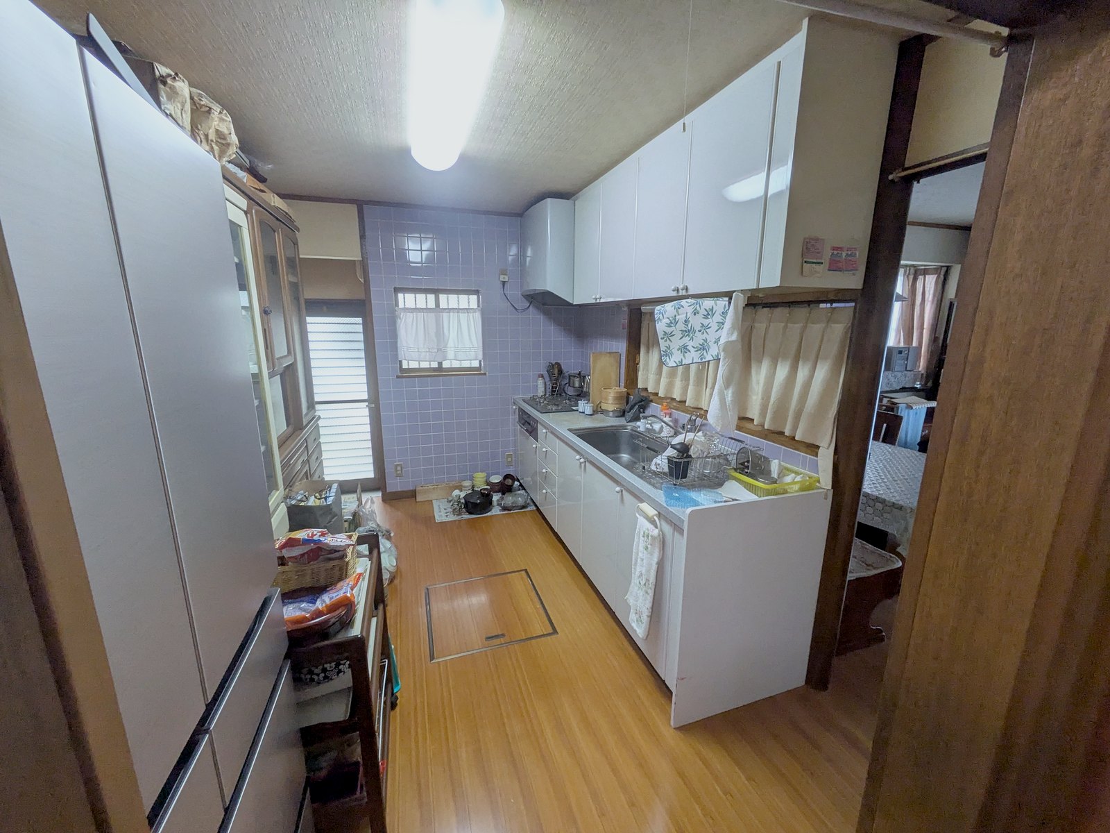 改修前のキッチン。柱と垂れ壁で仕切られた独立型。壁は紫のタイル張り