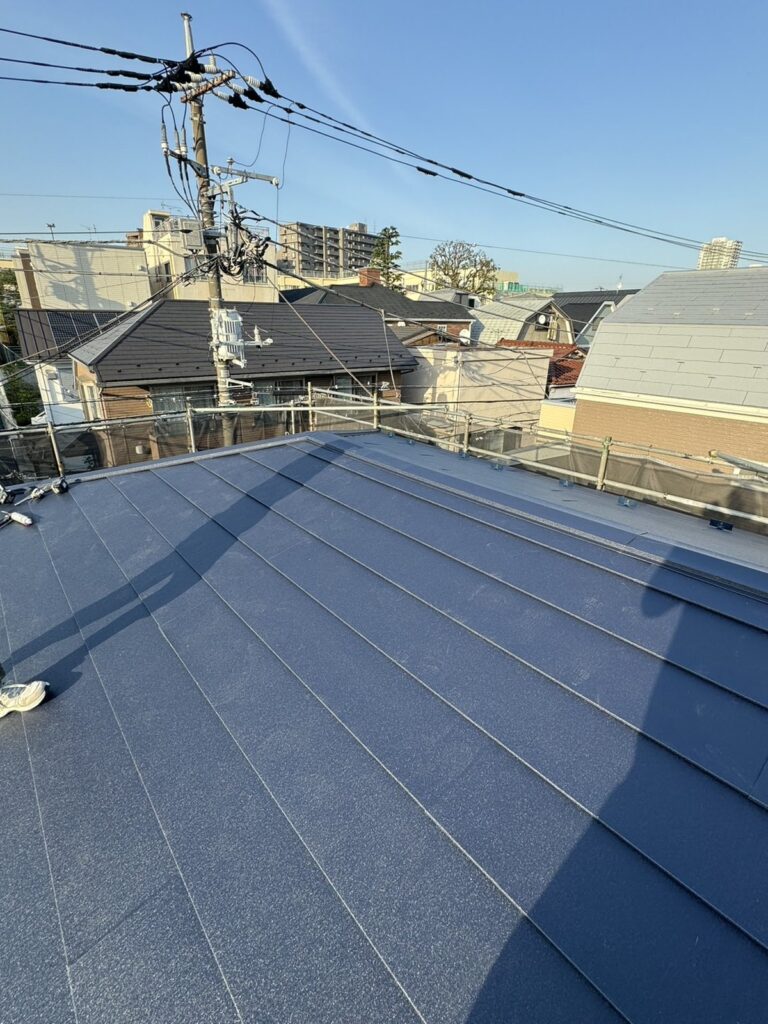 戸建て屋根カバー工事施工後。ネイビーの金属屋根材が葺き上がった屋根面