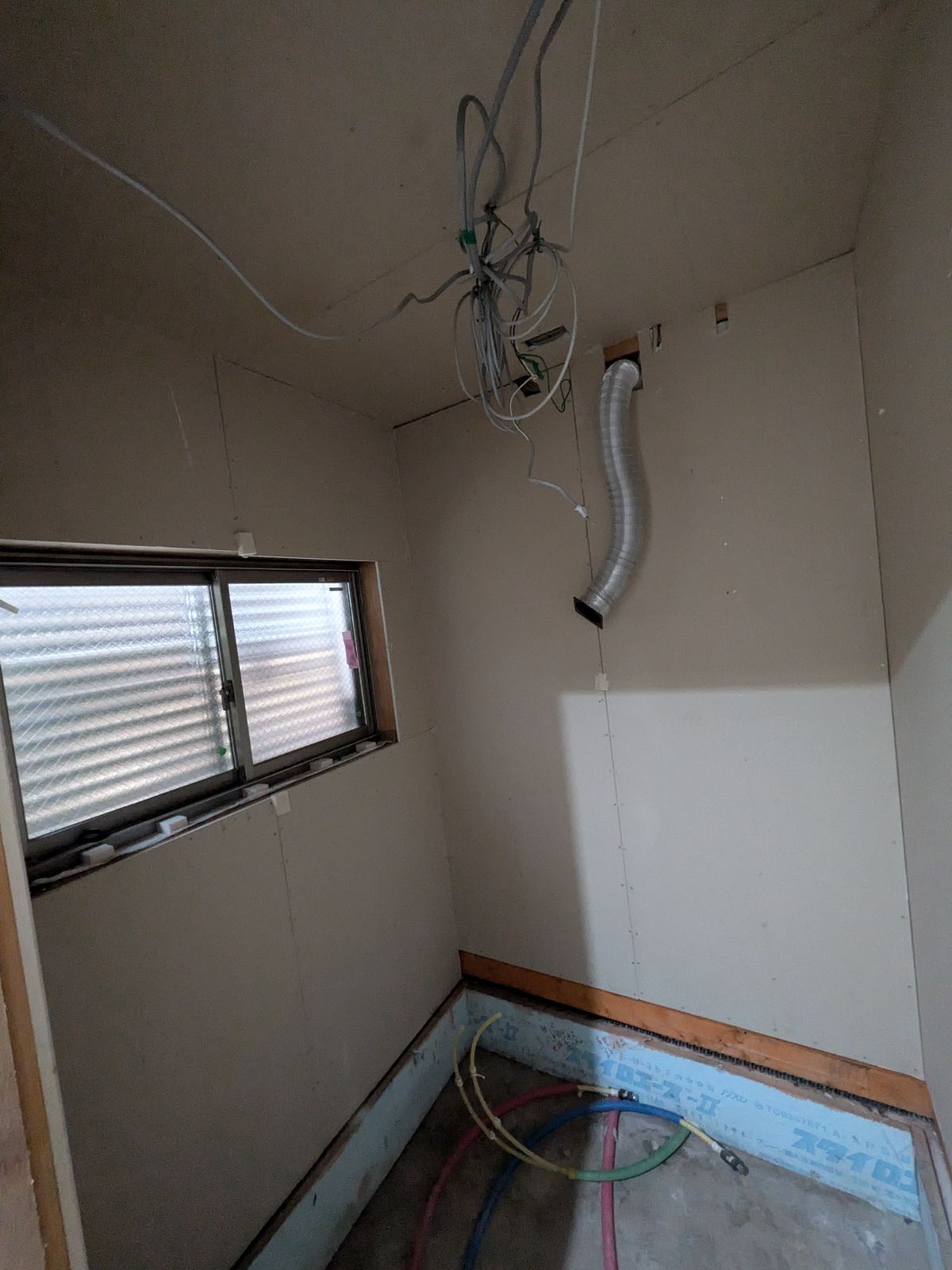 既存のユニットバスを解体した浴室。窓と換気ダクト、電気の配線が見えている