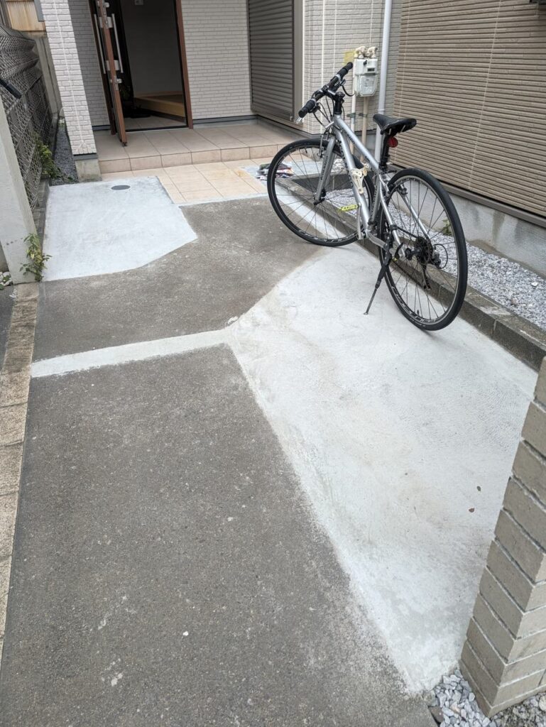 土間コンクリートで仕上げた駐車スペースと玄関までのアプローチ